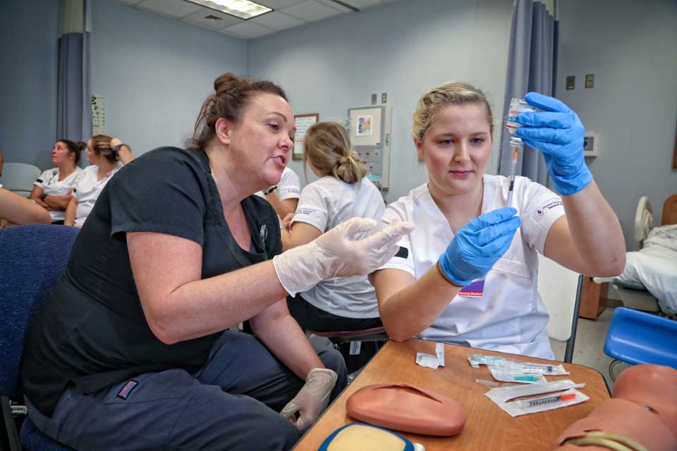 Nursing students practicing giving shots